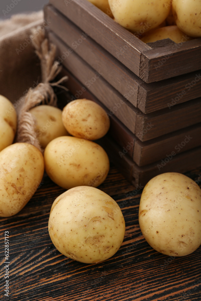 Raw potatoes on wooden background