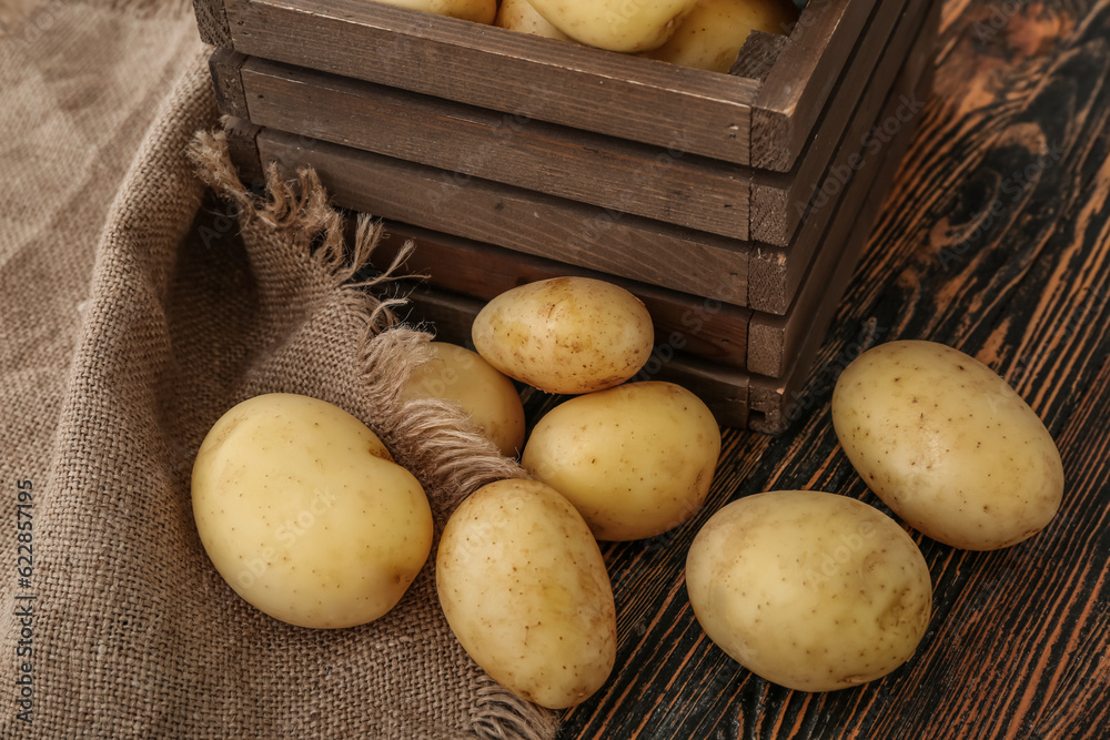 Raw potatoes on wooden background