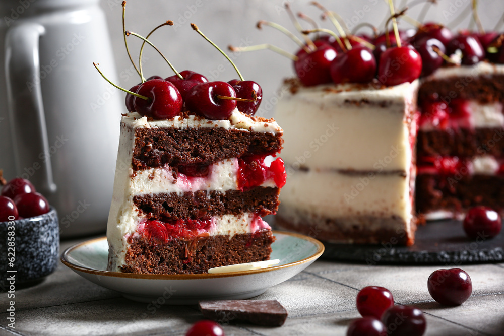 Tasty cherry cake and plate with piece on grey tile table