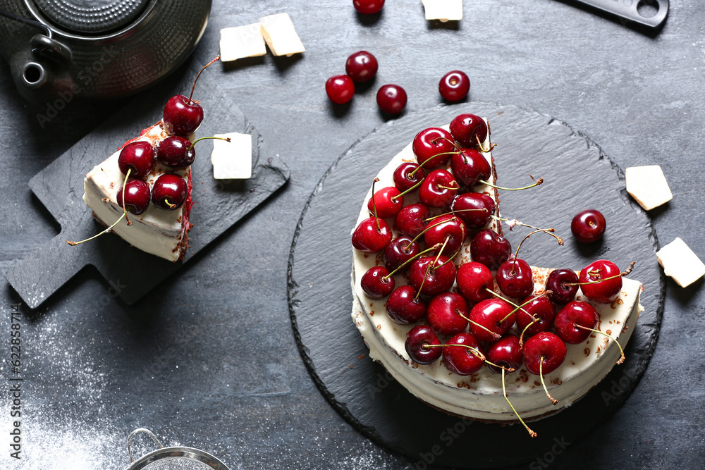 Tasty cherry cake and board with piece on black table