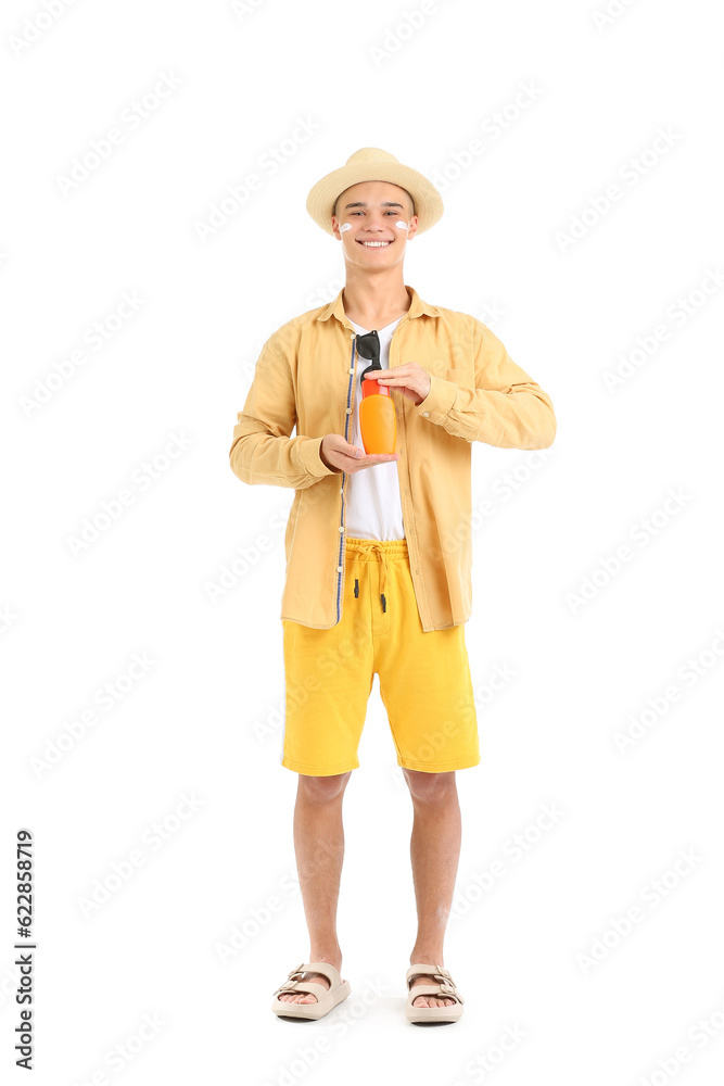 Happy young man with bottle of sunscreen cream isolated on white background