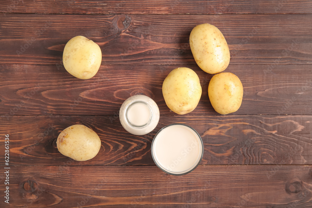 Bottle and glass of tasty potato milk on wooden background