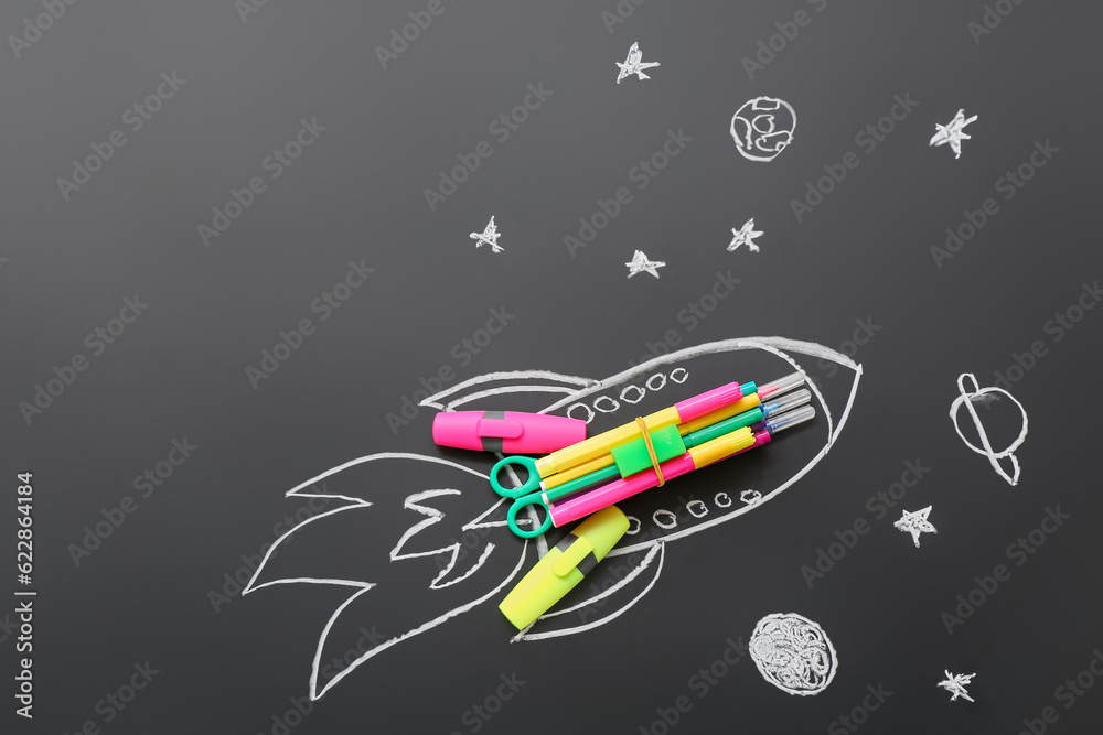 Drawn rocket with stationery on black background