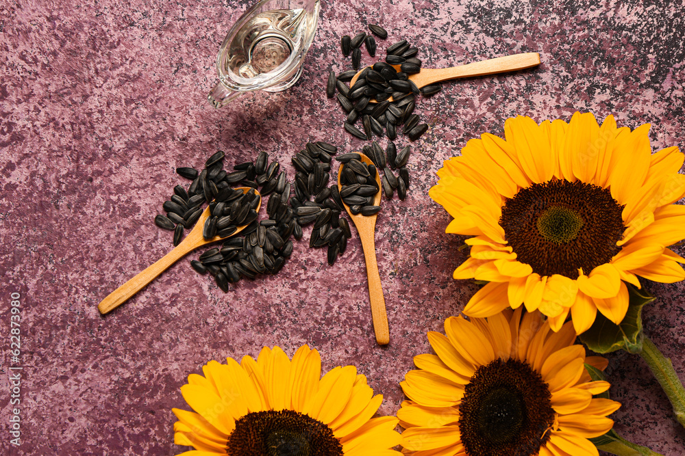 Sunflower, spoons with seeds and oil on purple background