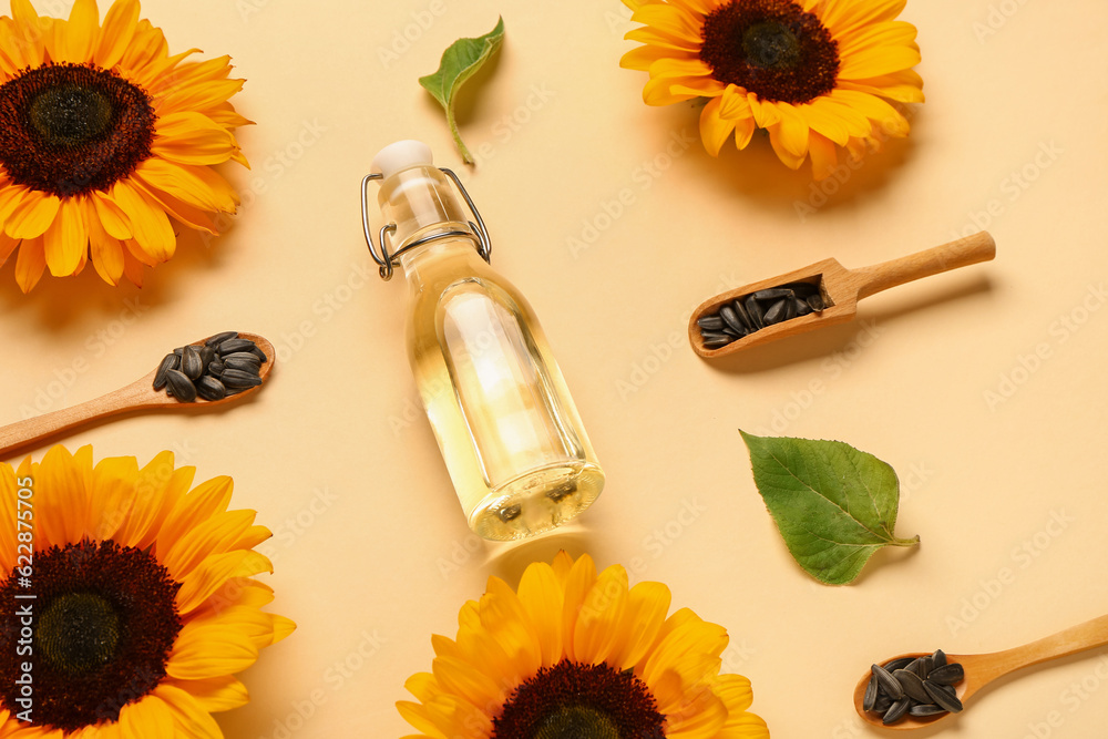 Sunflowers, seeds and bottle of oil on yellow background