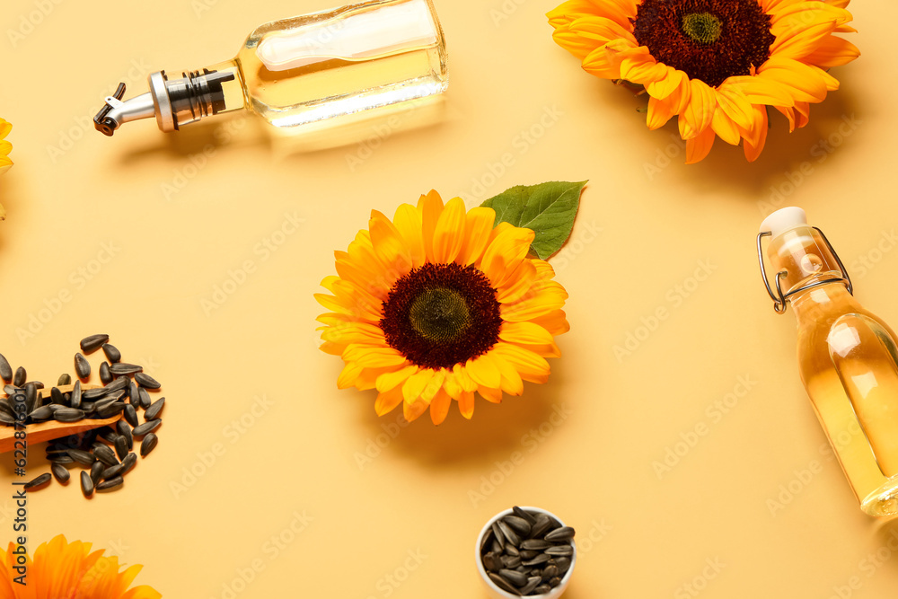 Sunflowers, seeds and bottles of oil on yellow background