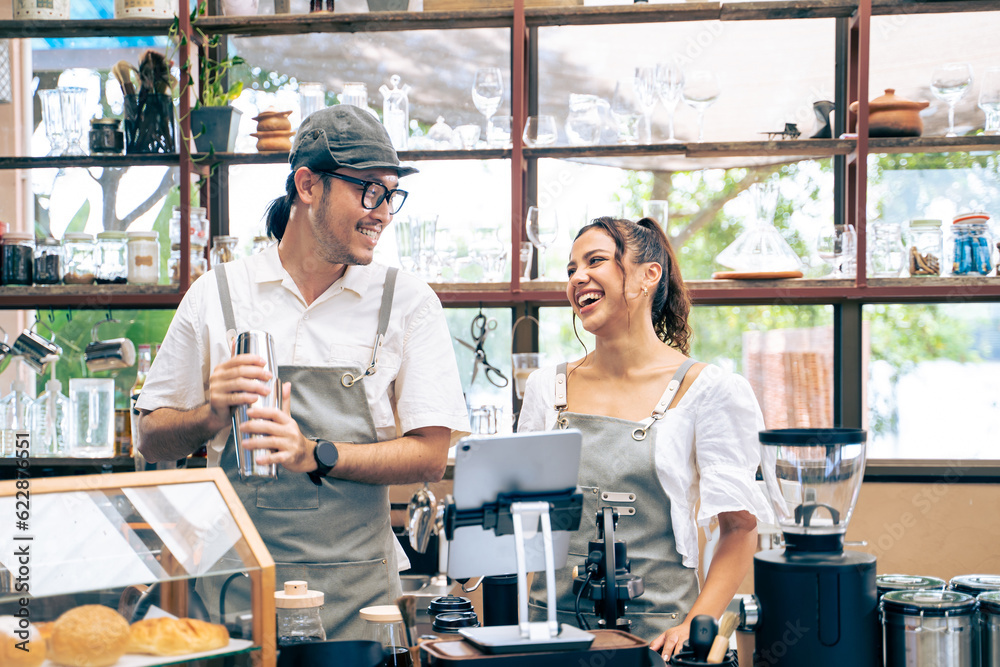 Asian attractive barista and Caucasian waitress working in coffeehouse. 