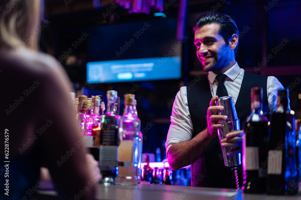 Caucasian profession bartender making a cocktail for women at a bar. 