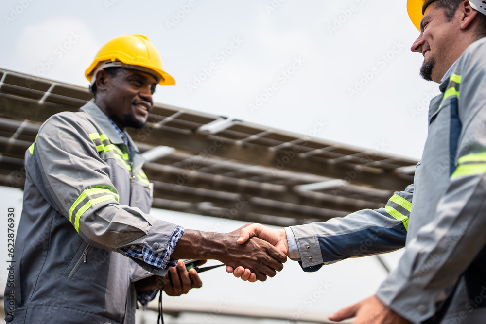 Young engineer making handshake, work with photovoltaic panel system. 