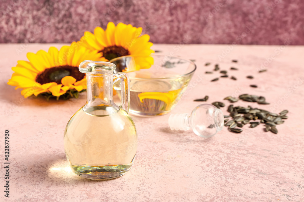 Decanter of sunflower oil on pink background