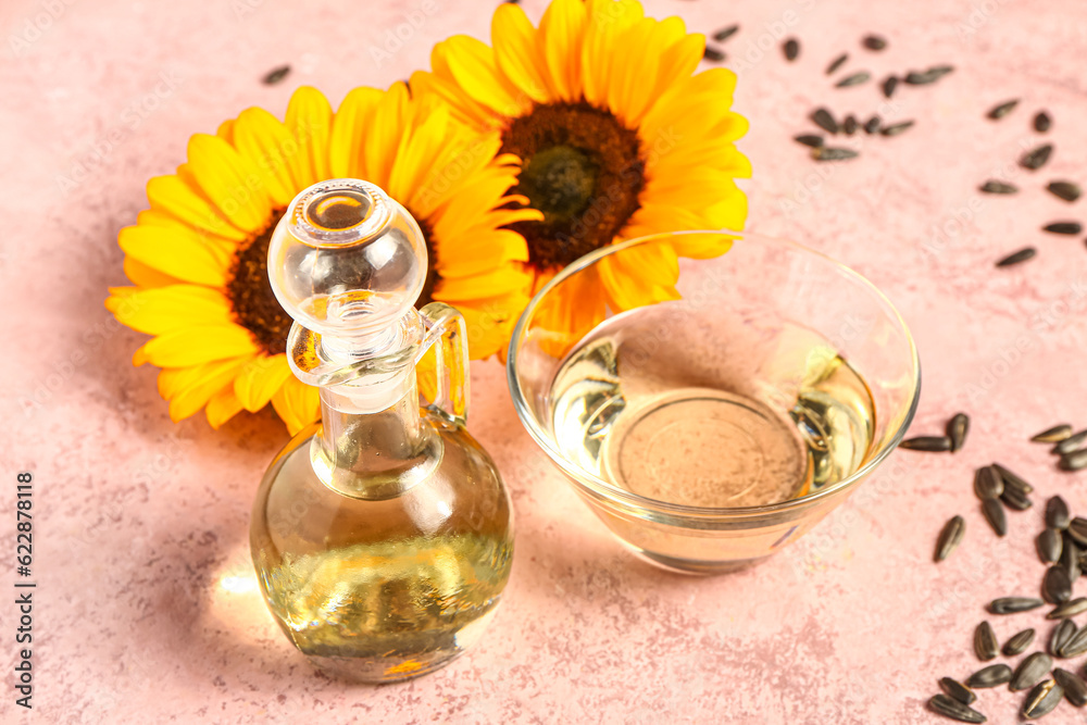 Bowl and decanter of sunflower oil on pink background