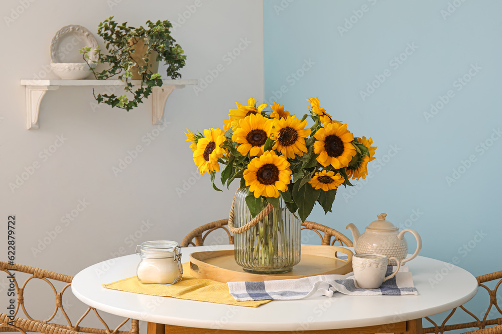 Vase with beautiful sunflowers on dining table