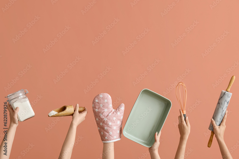 Female hands with baking utensils on pink background