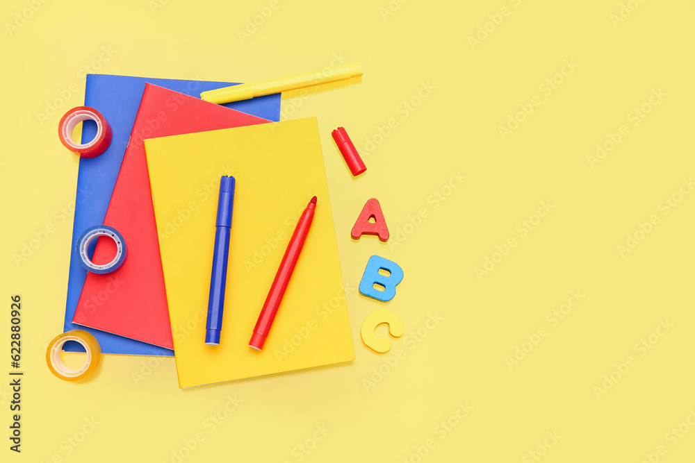 Notebooks with stationery on yellow background