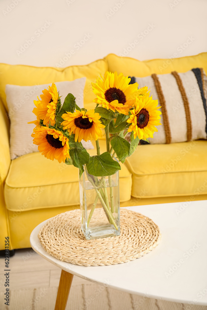 Vase with beautiful sunflowers on coffee table in interior of living room