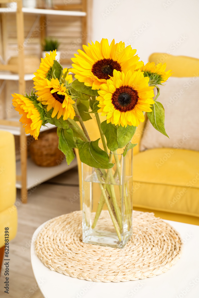 Vase with beautiful sunflowers on coffee table in interior of living room