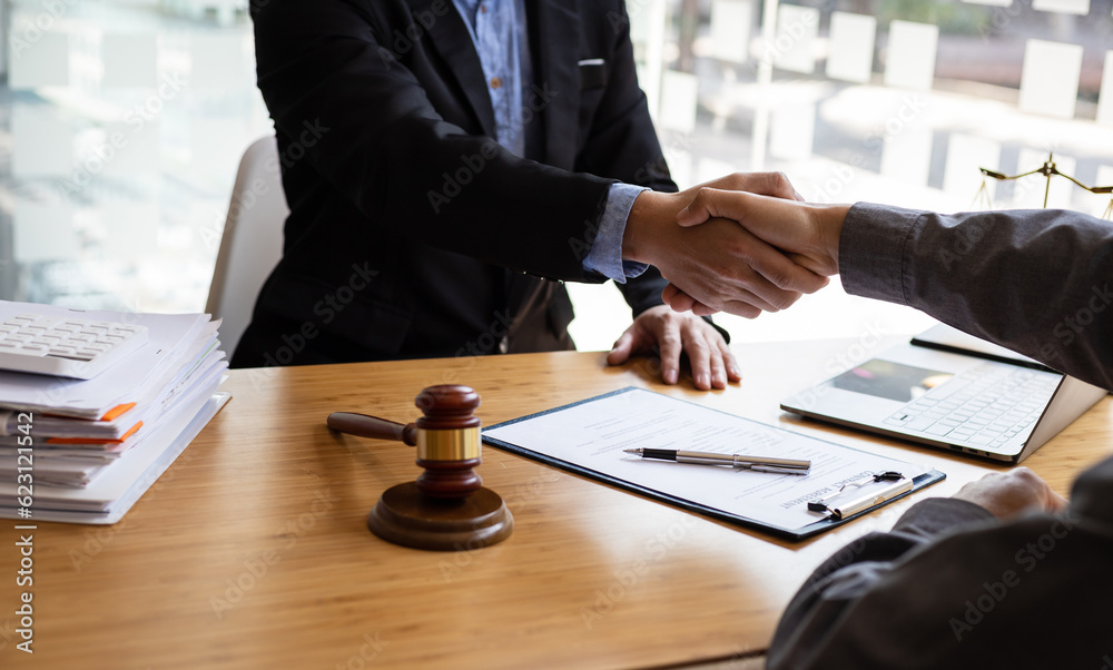 Businessman shaking hands to seal a deal with his partner lawyers or attorneys discussing a contract