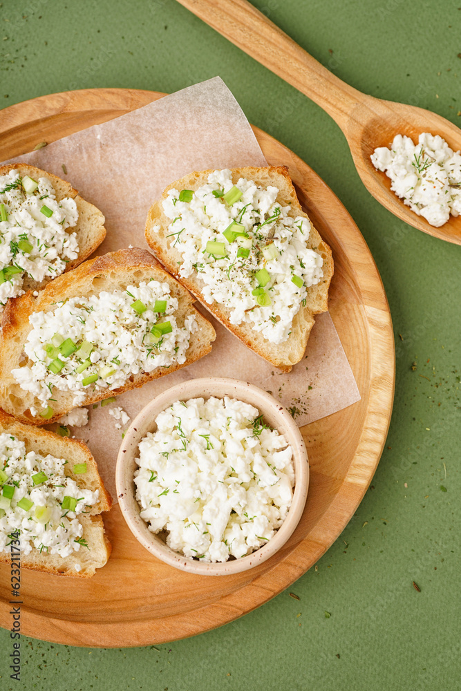 Sandwiches with tasty cottage cheese and green onion on color background