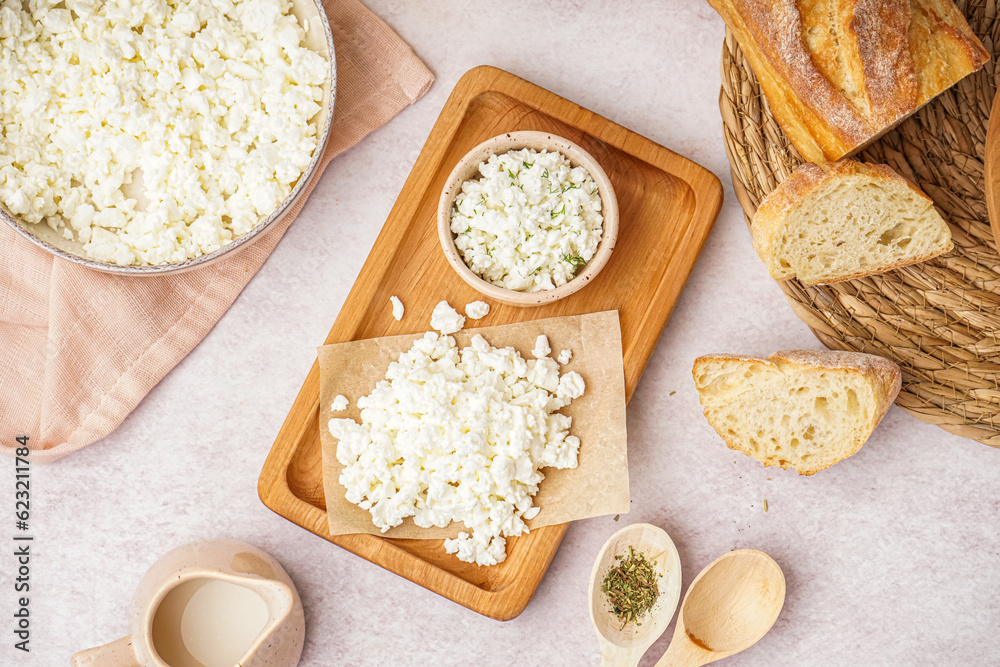 Wooden board with tasty cottage cheese on light background