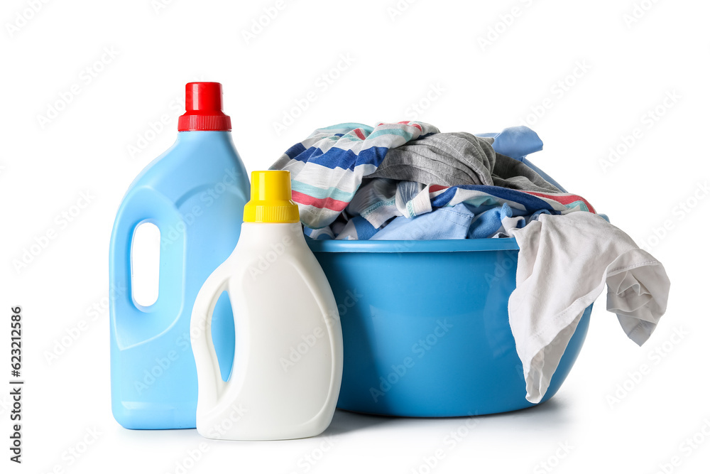 Plastic basin with dirty clothes and bottles of laundry detergent isolated on white background