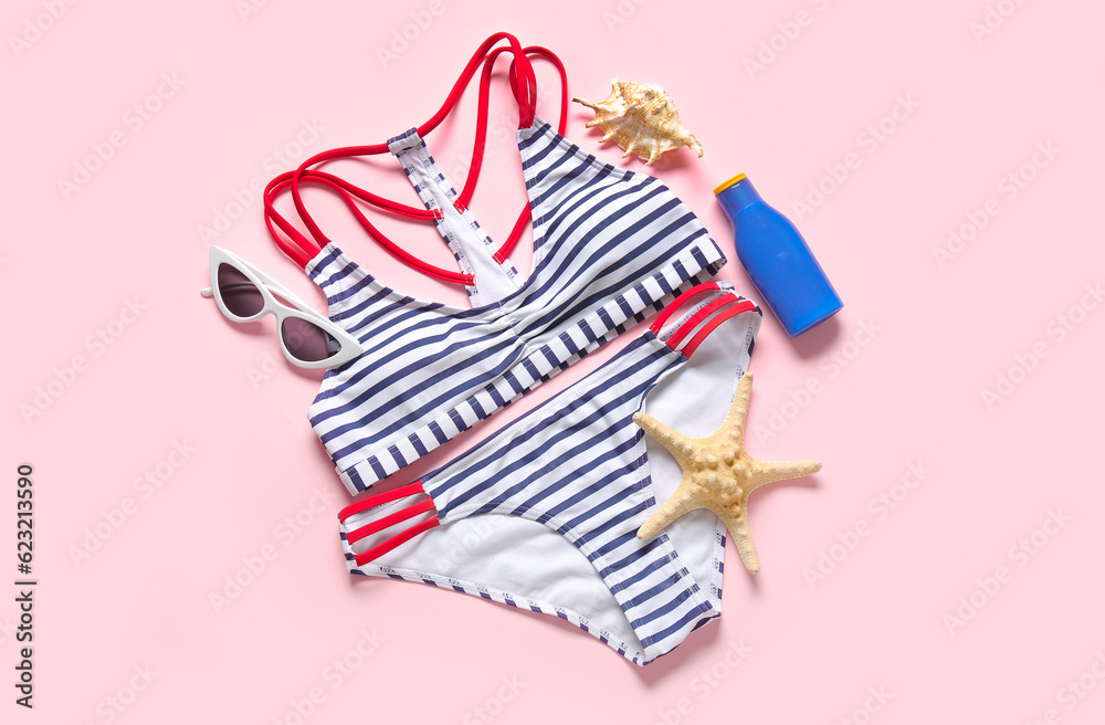 Stylish swimsuit, sunglasses, sunscreen cream and starfish on pink background