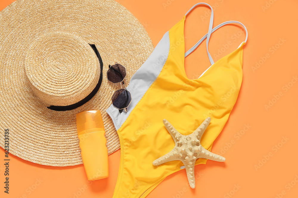 Stylish swimsuit, hat, sunglasses, bottle of sunscreen cream and starfish on color background