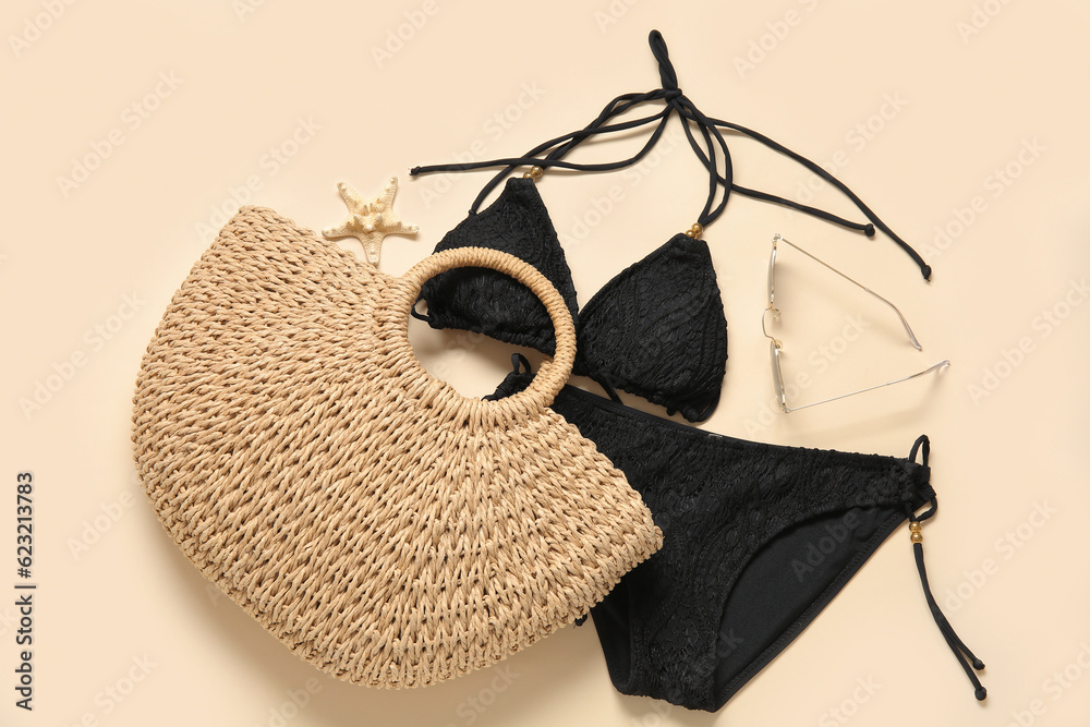 Stylish swimsuit, bag and sunglasses on color background