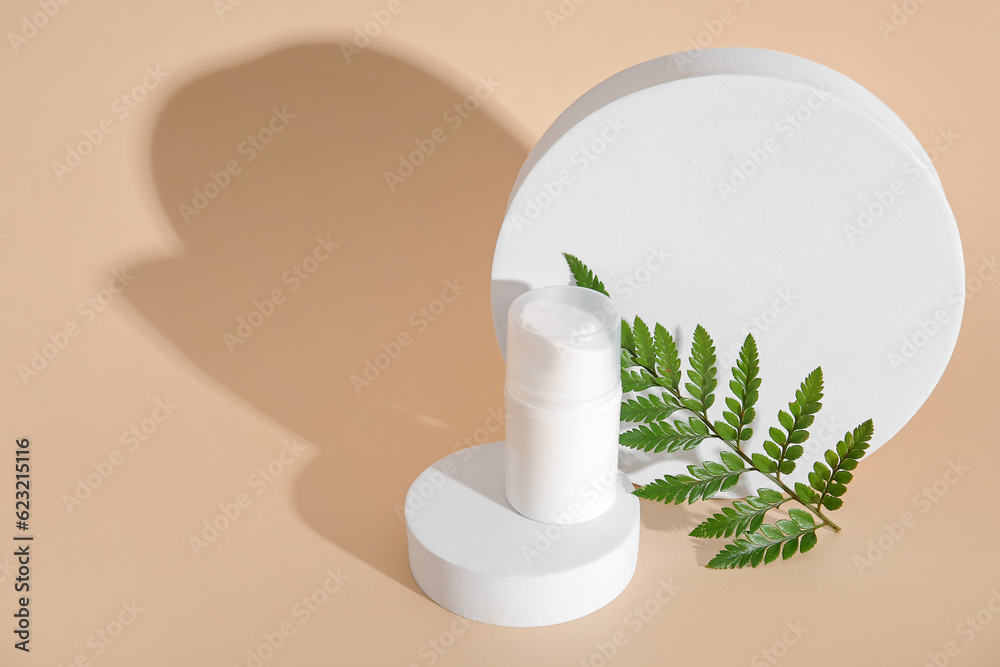 Composition with bottle of cosmetic product, plaster podiums and fern leaf on color background