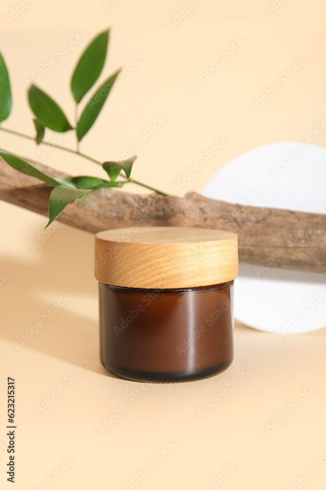 Jar of cosmetic product, tree branch, plaster podium and plant leaf on color background