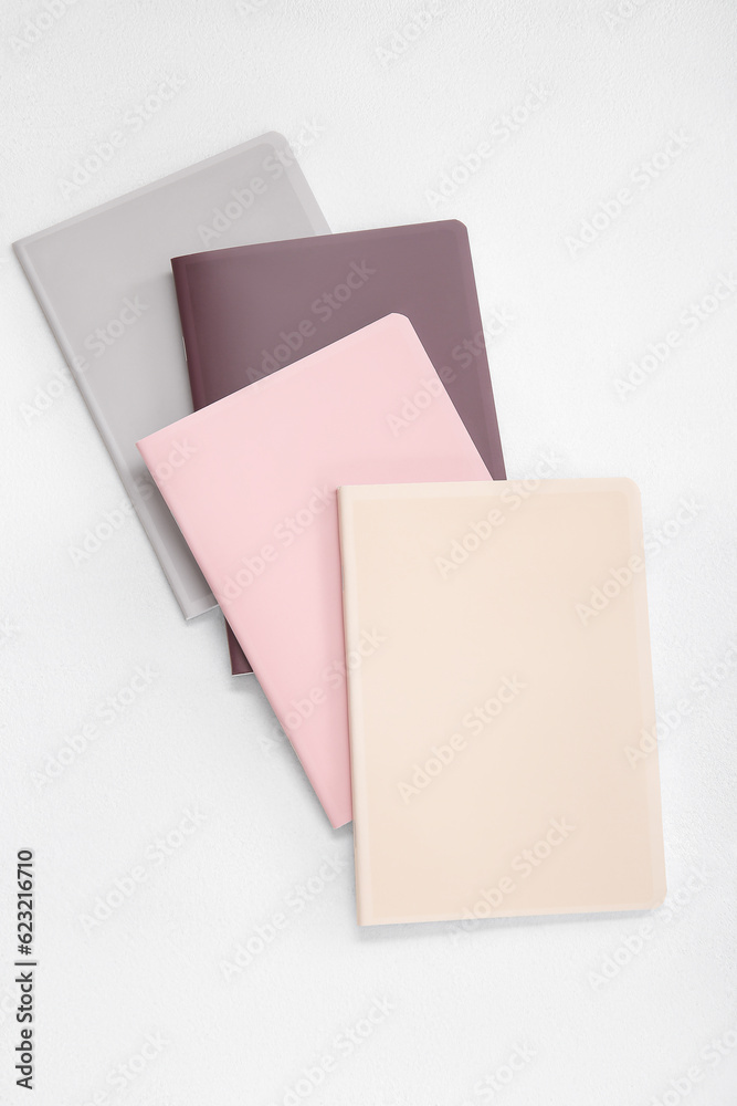 Different colorful notebooks on white background