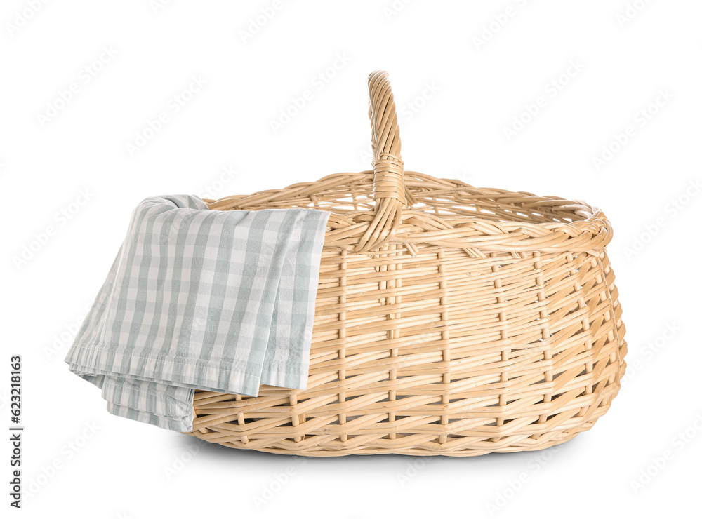 Wicker picnic basket with checkered napkin on white background