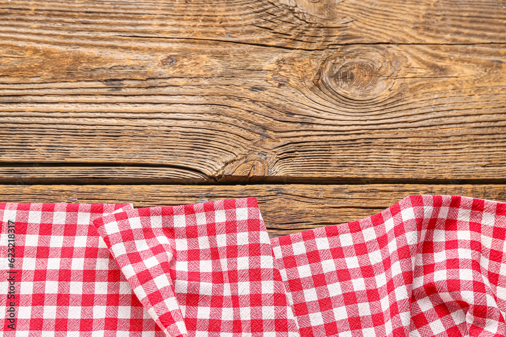 Red checkered napkin on wooden background, closeup