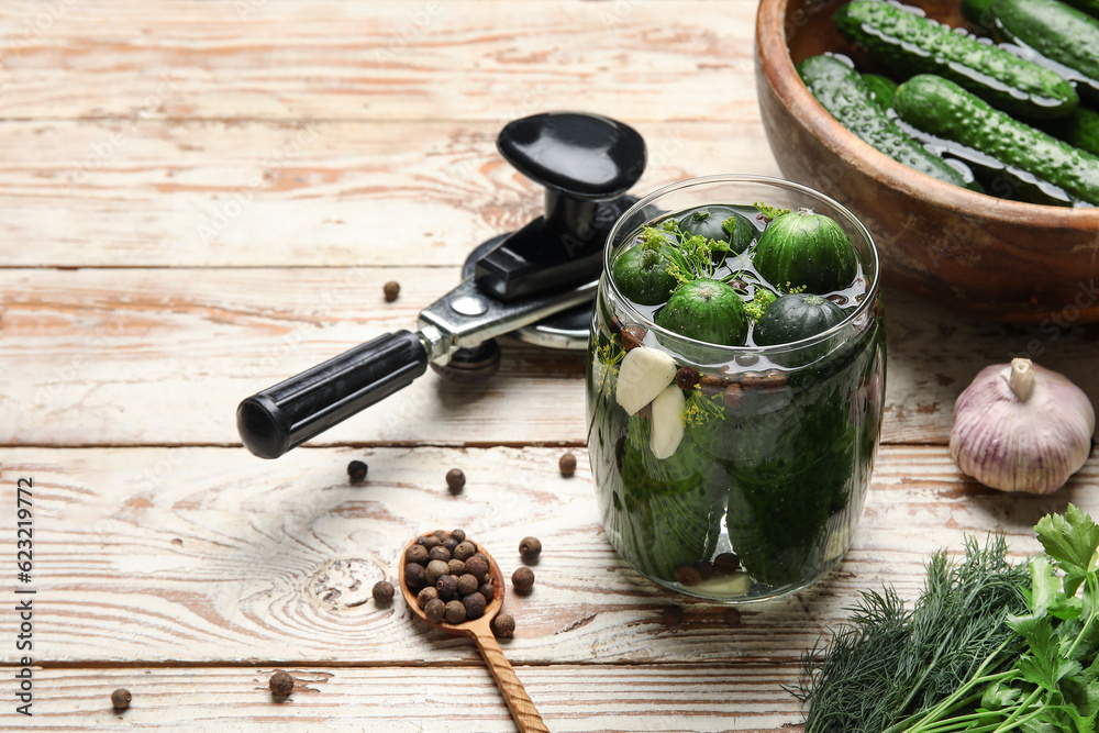 Jar with fresh cucumbers for preservation on light wooden background