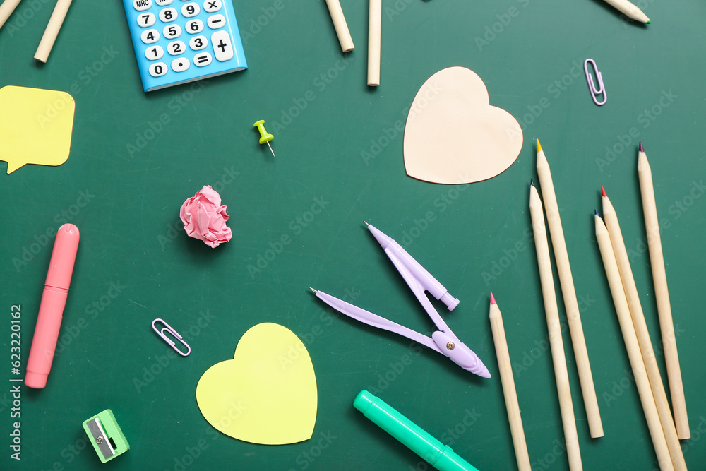 Calculator with different stationery on green chalkboard