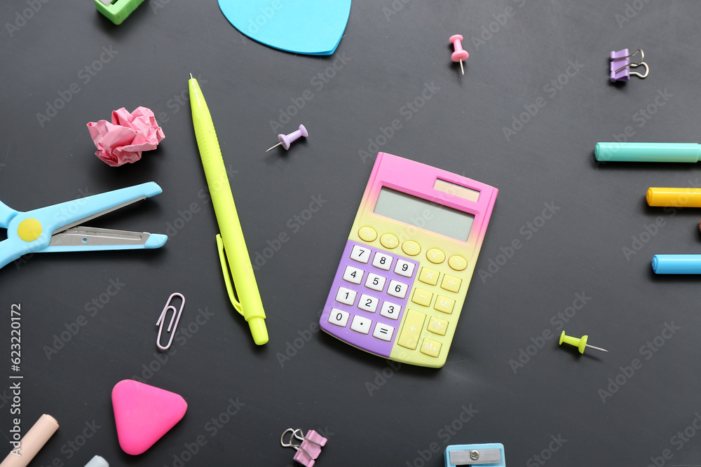 Calculator with different stationery on black chalkboard