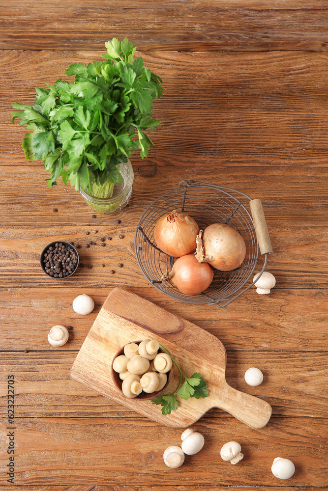 Bowl with canned mushrooms and ingredients for preservation on wooden background