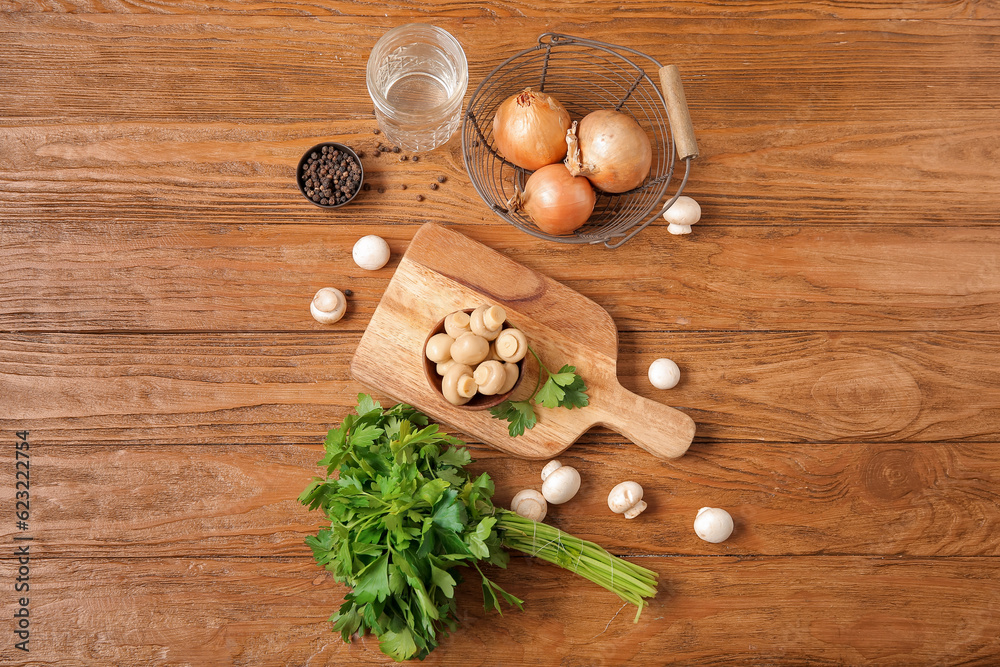 Bowl with canned mushrooms and ingredients for preservation on wooden background