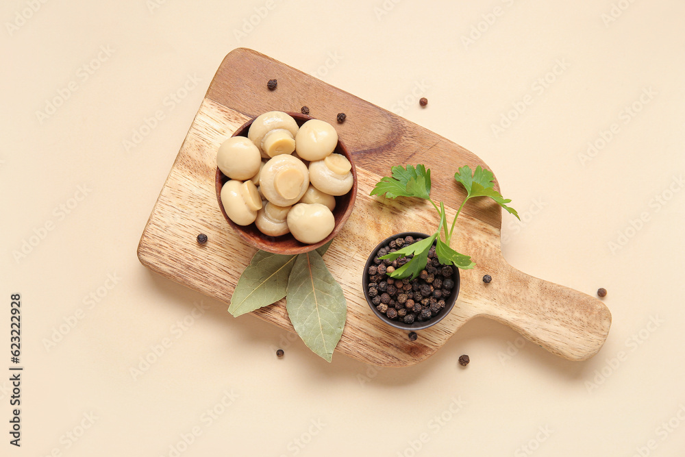 Bowl with canned mushrooms and spices on beige background