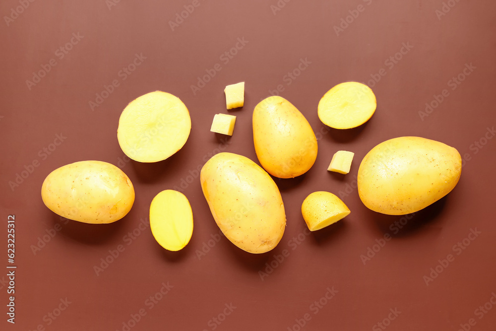 Raw potatoes on brown background