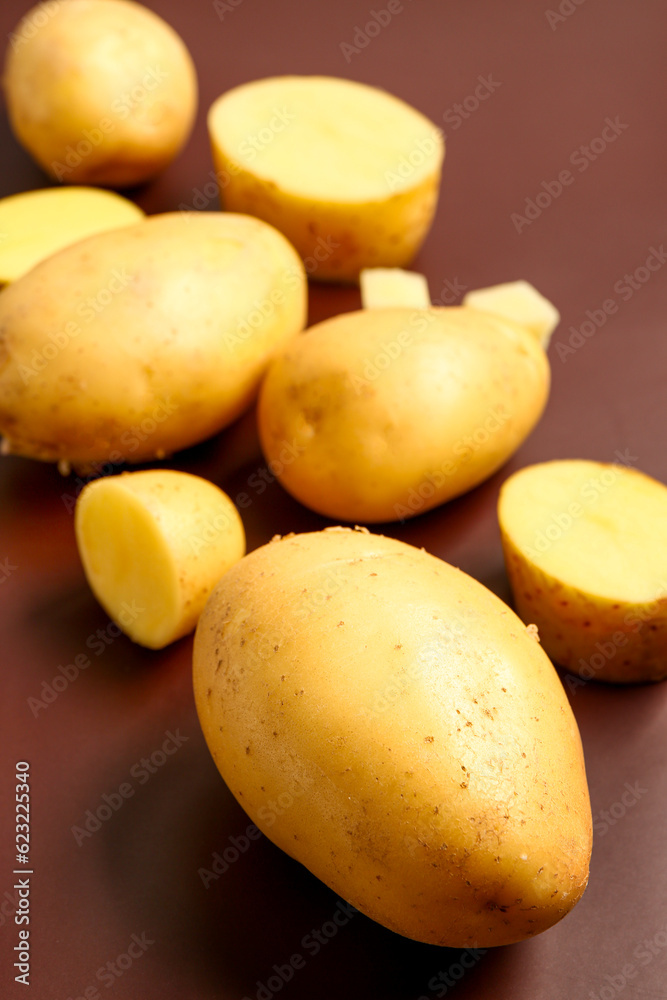 Raw potatoes on brown background