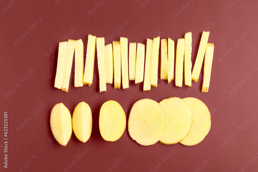 Pieces of raw potato on brown background