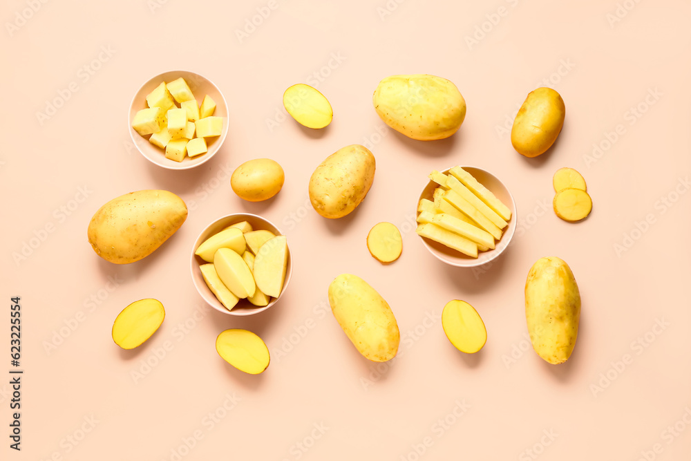 Bowls with cut and whole potatoes on pink background