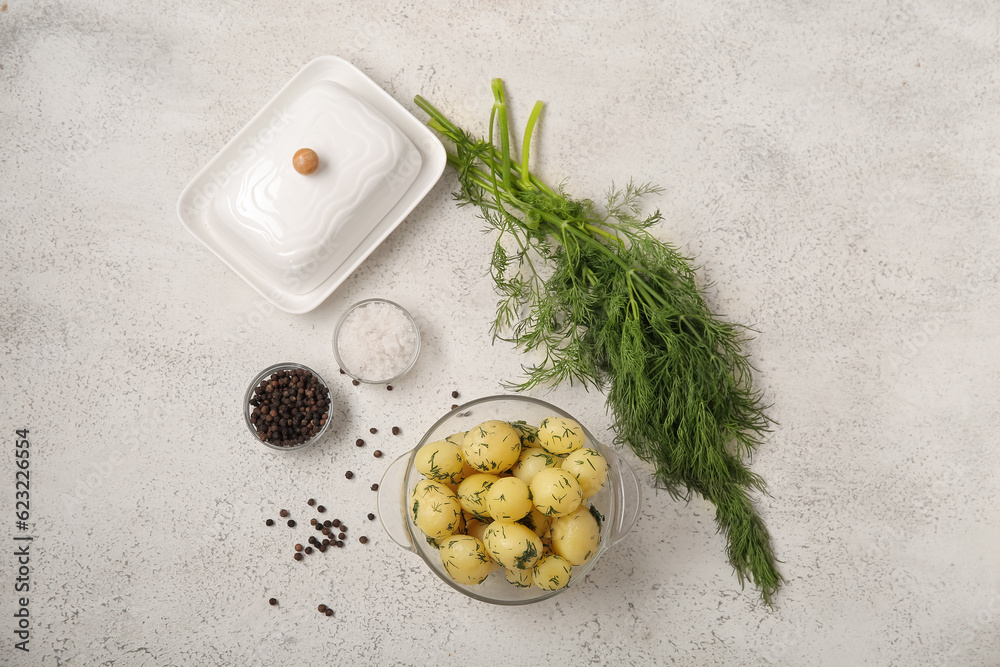 Bowl with boiled baby potatoes on light background