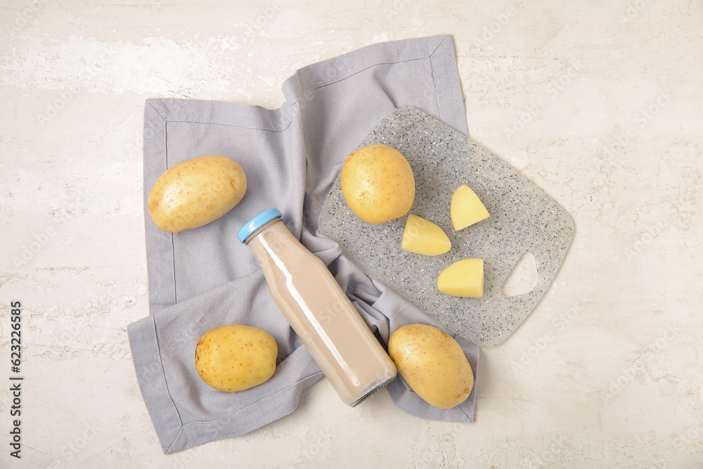 Bottle of tasty potato milk on light background