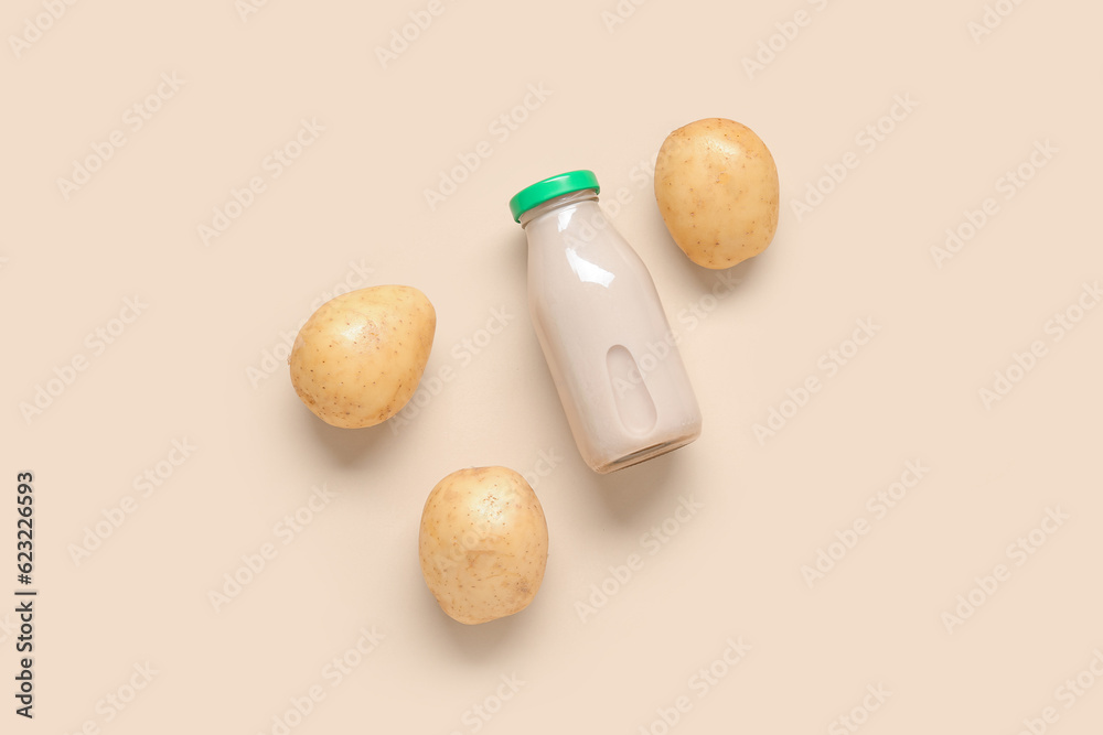 Bottle of tasty potato milk on beige background