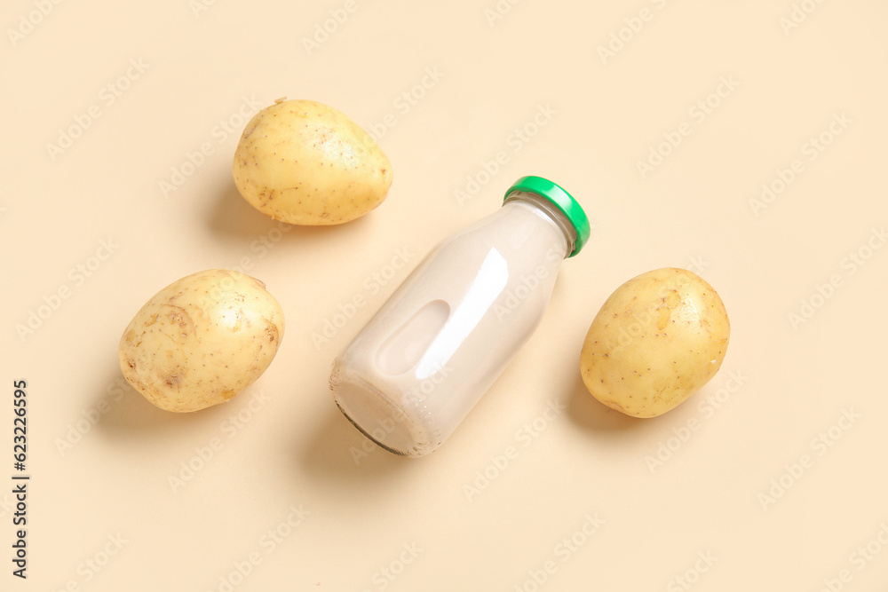 Bottle of tasty potato milk on beige background