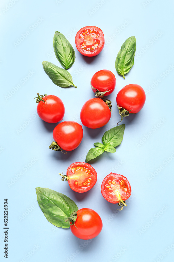 Fresh cherry tomatoes and basil on blue background