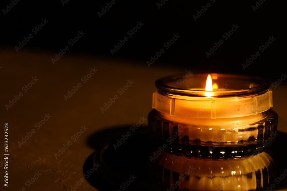 Beautiful burning candle on black background