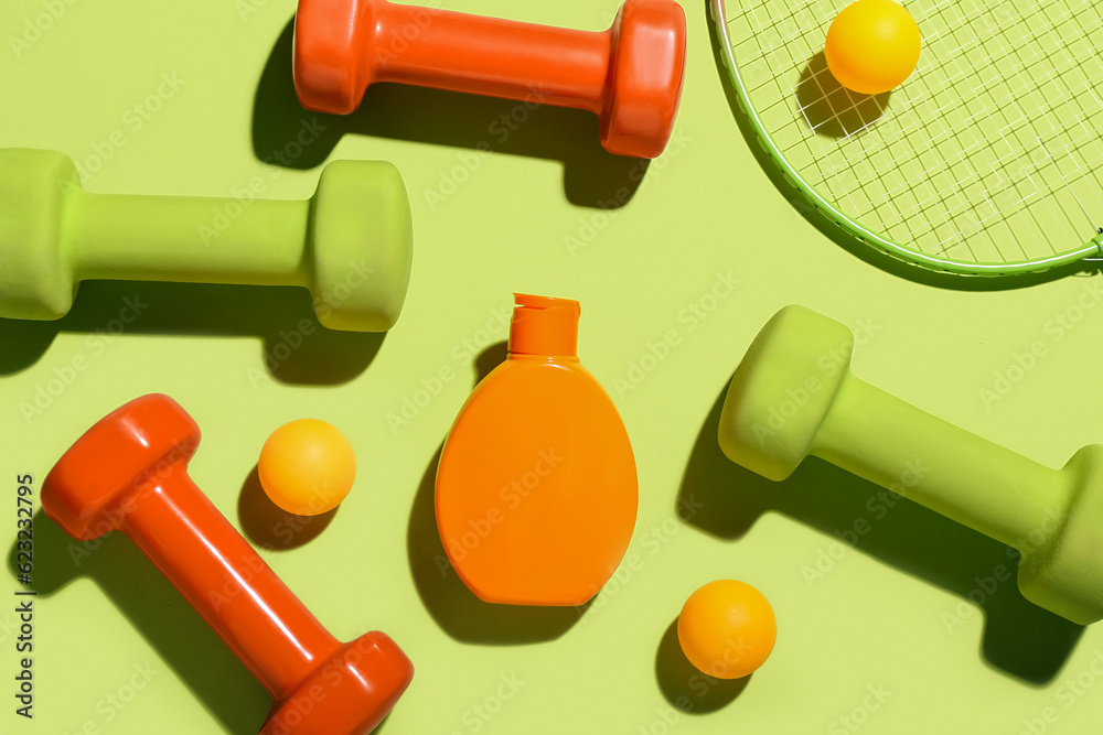 Composition with bottle of sunscreen cream, dumbbells and ping pong balls on color background