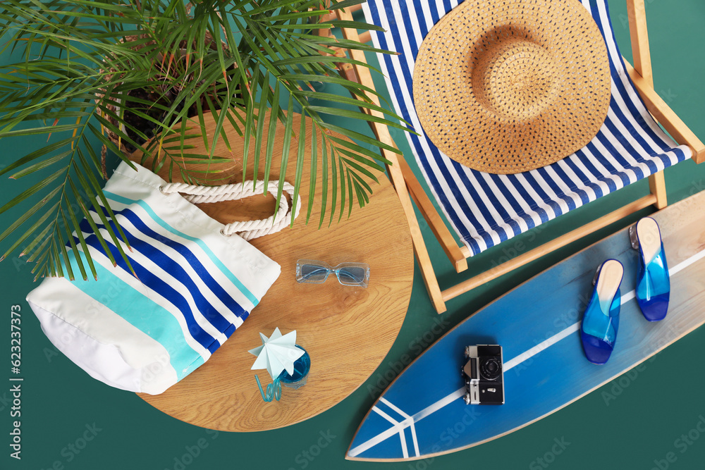 Deckchair, beach accessories and palm tree on color background